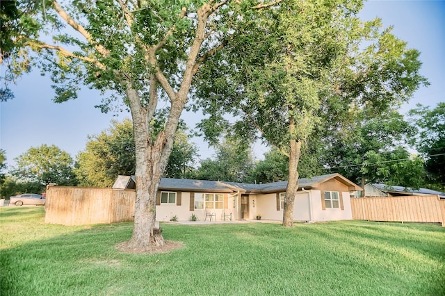 view of front of house with fence, a front lawn, and stucco siding