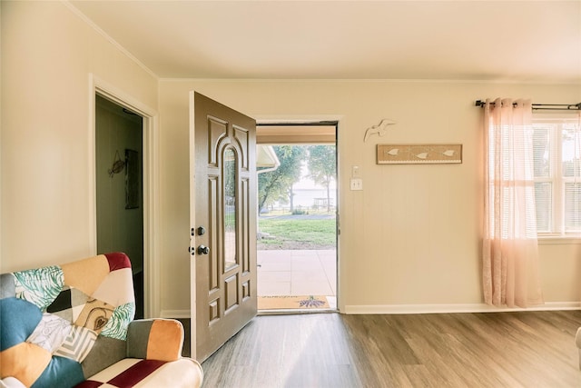 entryway with baseboards, wood finished floors, and crown molding