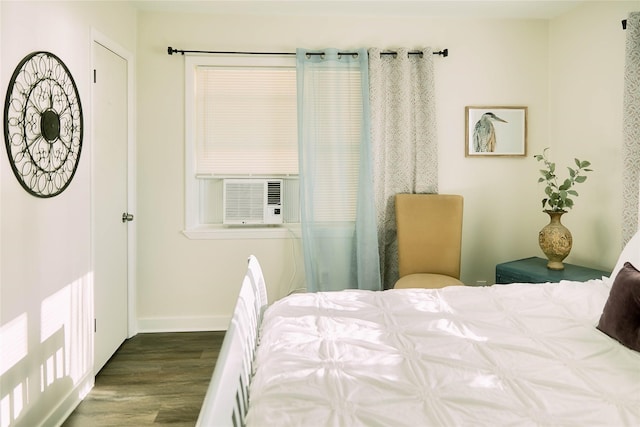 bedroom featuring cooling unit, wood finished floors, and baseboards