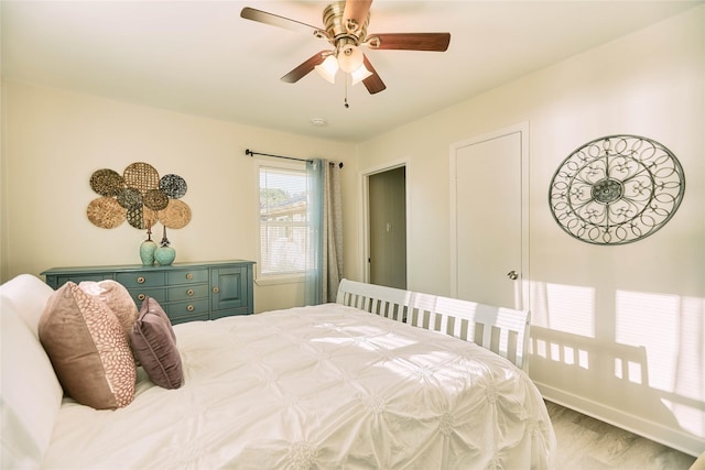 bedroom featuring ceiling fan, baseboards, and wood finished floors