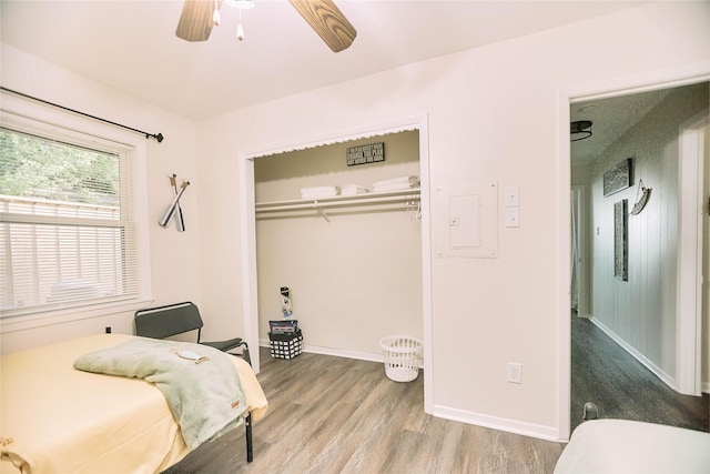 bedroom featuring a closet, ceiling fan, baseboards, and wood finished floors