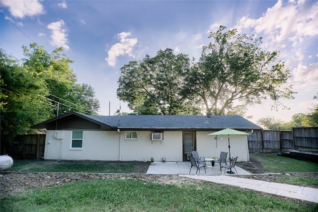 back of house with a yard, a patio area, fence, and brick siding