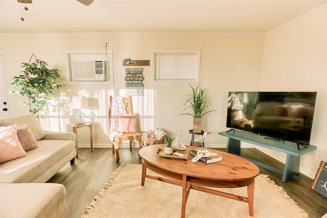 living room with wood finished floors, a ceiling fan, and baseboards