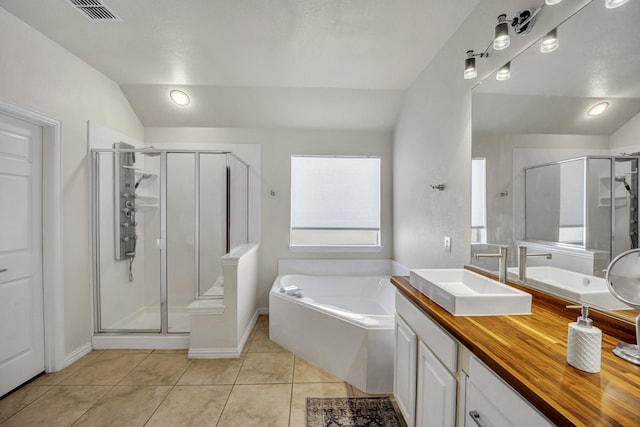 bathroom featuring lofted ceiling, tile patterned flooring, a sink, visible vents, and a stall shower