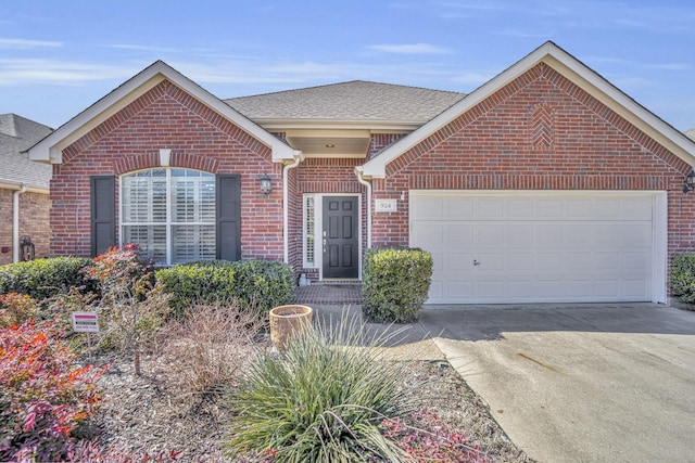 view of front of property featuring a garage, concrete driveway, brick siding, and a shingled roof