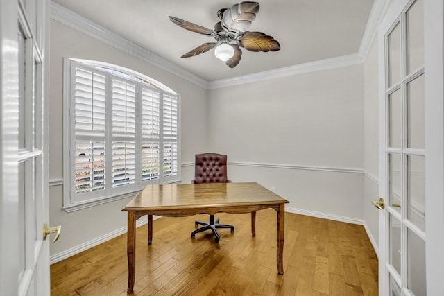 office area with light wood-style floors, crown molding, baseboards, and a ceiling fan