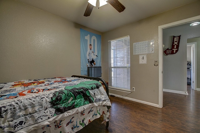 bedroom with a ceiling fan, baseboards, and wood finished floors