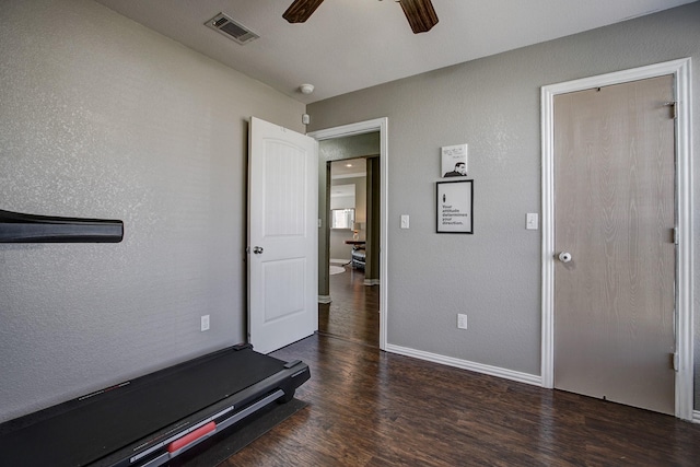 workout room with baseboards, visible vents, a textured wall, ceiling fan, and wood finished floors