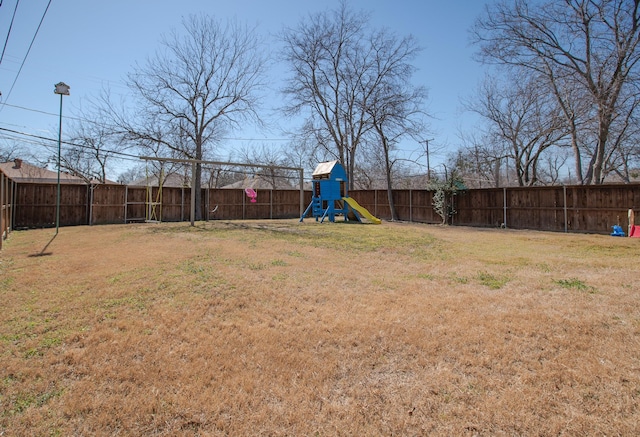 view of yard with a fenced backyard and a playground