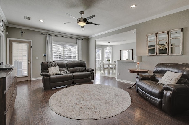 living room with dark wood-style flooring, visible vents, ornamental molding, a ceiling fan, and baseboards