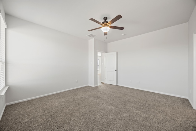 carpeted empty room with baseboards, visible vents, and ceiling fan