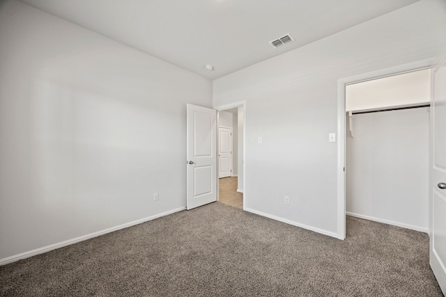 unfurnished bedroom featuring carpet floors, a closet, visible vents, and baseboards