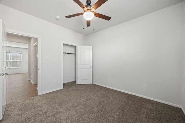 unfurnished bedroom with carpet floors, a ceiling fan, baseboards, and a closet