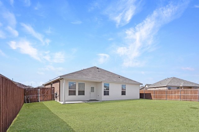 rear view of property featuring a patio, brick siding, a lawn, and a fenced backyard