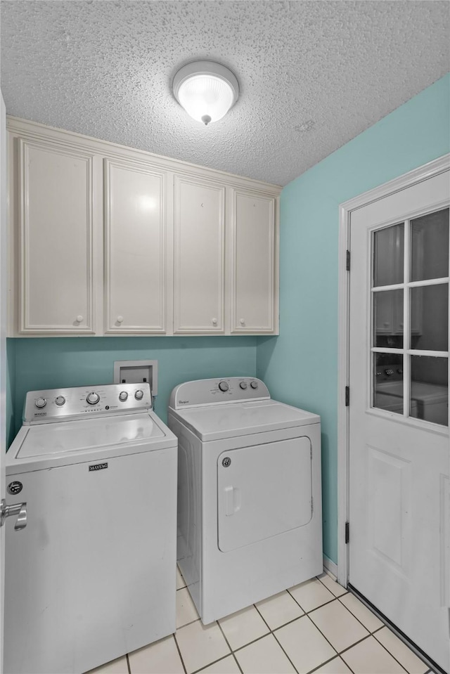 washroom with cabinet space, light tile patterned floors, a textured ceiling, and independent washer and dryer