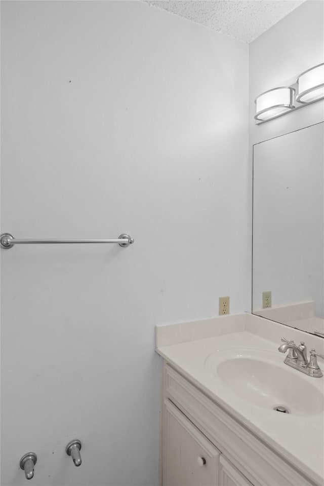 bathroom featuring a textured ceiling and vanity