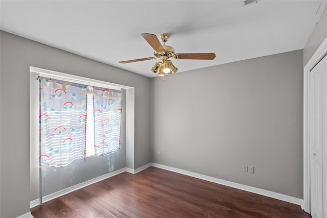 unfurnished room featuring visible vents, wood finished floors, a ceiling fan, and baseboards