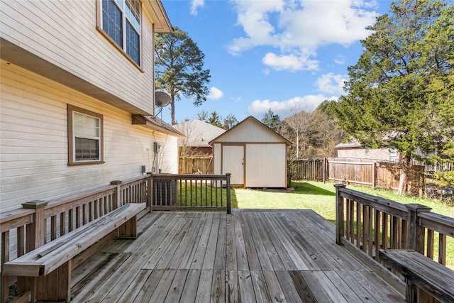 wooden deck featuring a yard, a fenced backyard, a storage unit, and an outbuilding