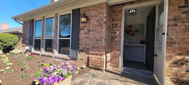 entrance to property featuring brick siding