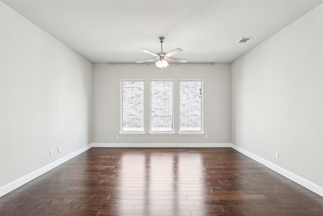 empty room featuring a ceiling fan, baseboards, visible vents, and dark wood-type flooring