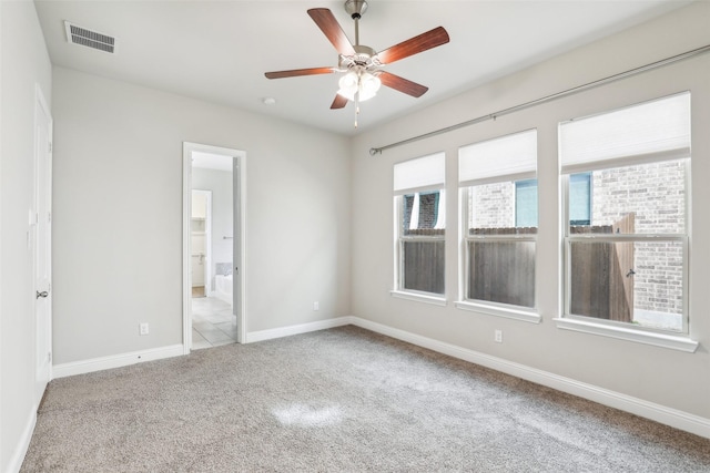 unfurnished room with ceiling fan, carpet floors, visible vents, and baseboards