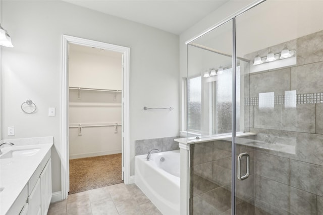 bathroom with a garden tub, tile patterned flooring, vanity, a spacious closet, and a shower stall