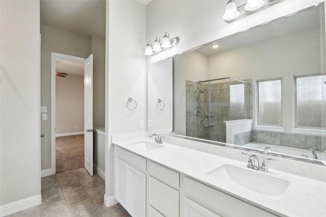 full bath with a stall shower, double vanity, a sink, and tile patterned floors