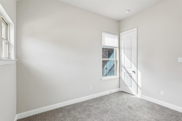 carpeted spare room featuring baseboards