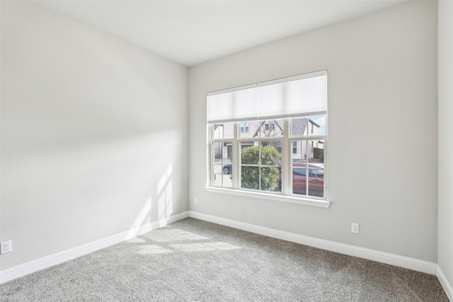 unfurnished room with carpet and baseboards