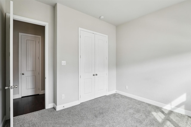 unfurnished bedroom featuring a closet, carpet, and baseboards