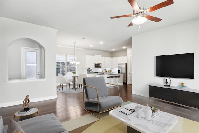 living room featuring ceiling fan with notable chandelier, dark wood-type flooring, recessed lighting, and baseboards