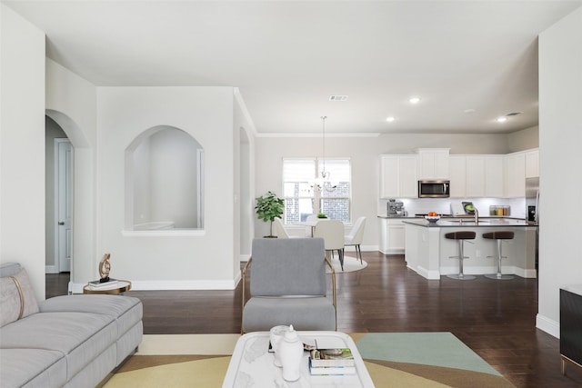 living area featuring recessed lighting, dark wood-type flooring, visible vents, baseboards, and an inviting chandelier