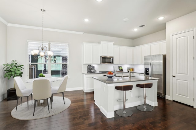 kitchen featuring visible vents, dark wood-style flooring, stainless steel appliances, a kitchen bar, and a sink