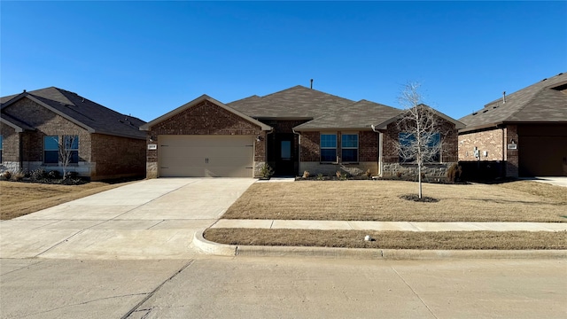 single story home with concrete driveway, brick siding, and an attached garage