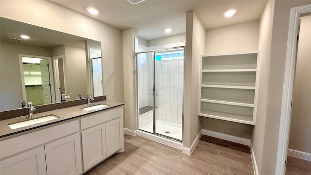 bathroom featuring a stall shower, a sink, a walk in closet, and wood tiled floor