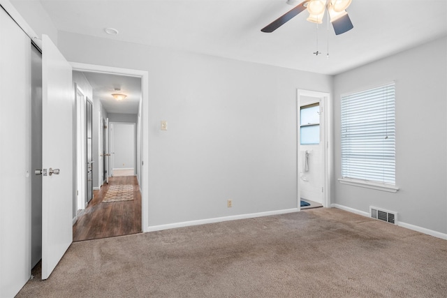 carpeted spare room featuring visible vents, ceiling fan, and baseboards