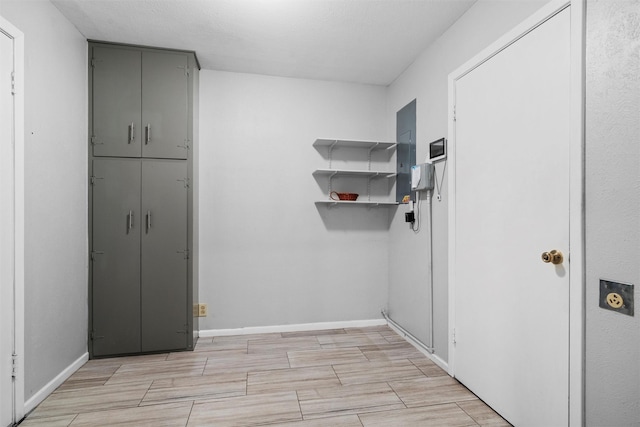 interior space featuring laundry area, wood tiled floor, and baseboards