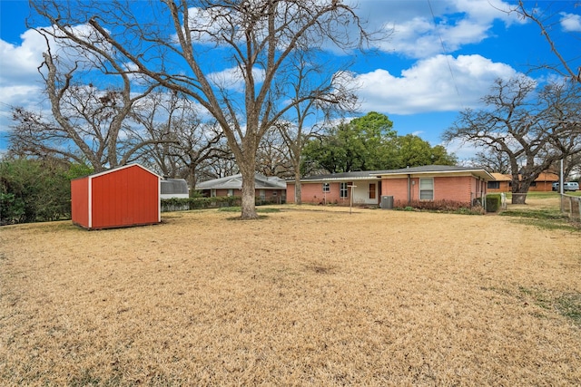 view of yard featuring central air condition unit, a storage shed, and an outdoor structure