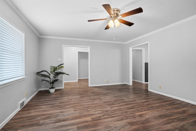 spare room with crown molding, visible vents, ceiling fan, and dark wood-style flooring