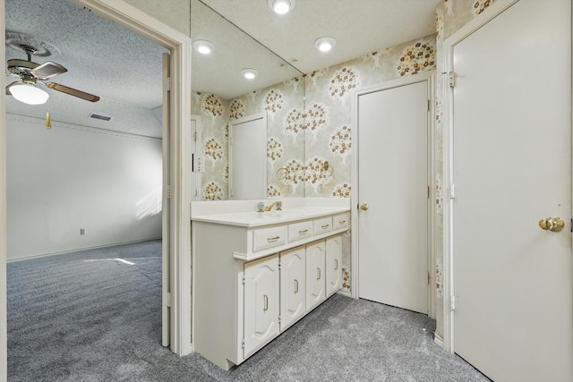 bathroom with ceiling fan, visible vents, a textured ceiling, and vanity