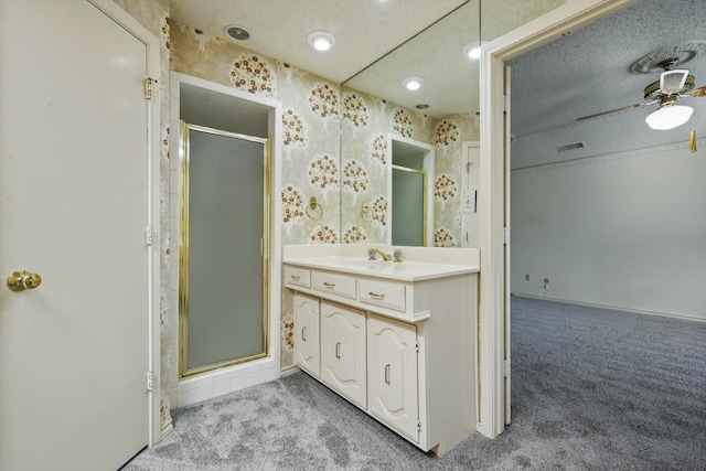 bathroom with visible vents, a ceiling fan, a stall shower, a textured ceiling, and vanity