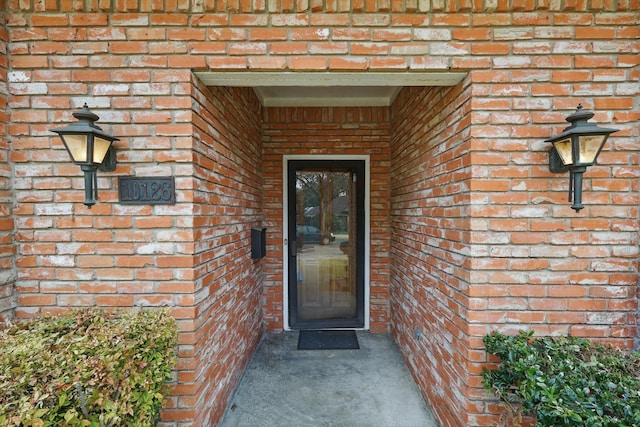 doorway to property featuring brick siding