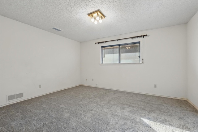 carpeted spare room featuring visible vents and a textured ceiling