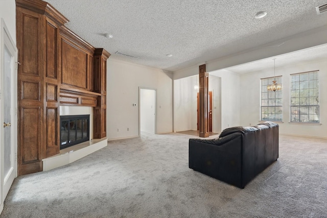 carpeted living area with a large fireplace, visible vents, a chandelier, and a textured ceiling