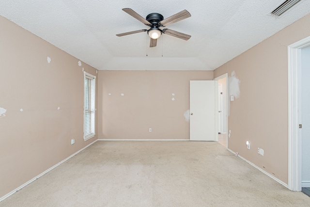 unfurnished room with light colored carpet, visible vents, a textured ceiling, and baseboards