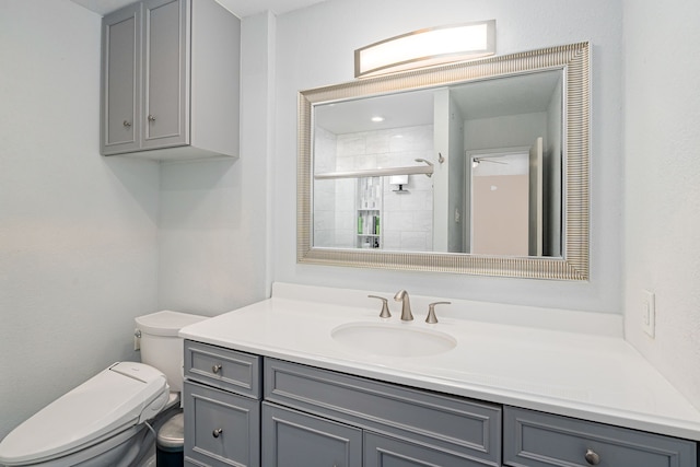 bathroom featuring vanity, a shower stall, and toilet