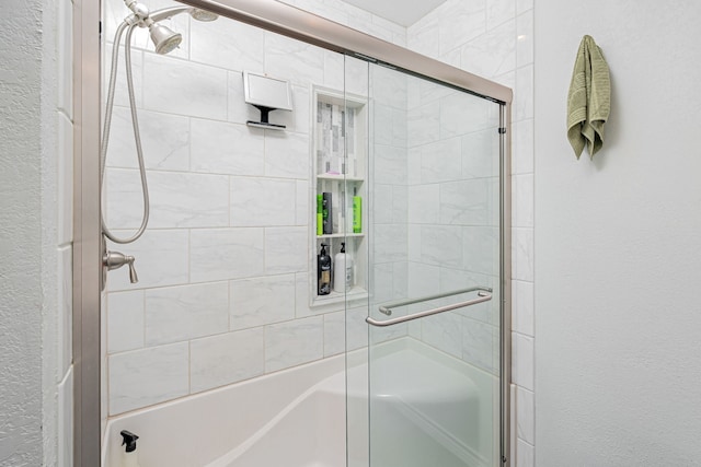 full bathroom featuring a textured wall and a shower with door