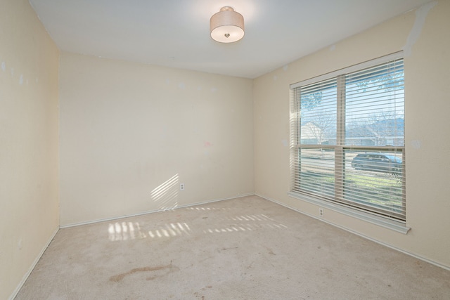 carpeted spare room featuring baseboards