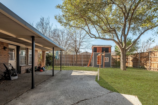 view of yard with an outbuilding, a storage shed, a patio area, and a fenced backyard