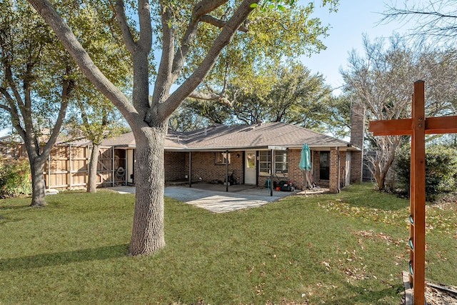 back of house featuring a yard, a patio area, brick siding, and fence